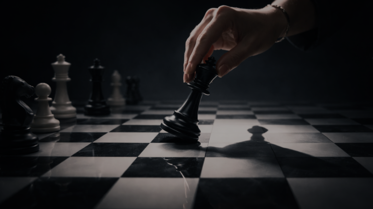 Kvinnohand flyttar schackpjäs i mörkt ljus, symbol för politisk strategi, retorik och makt.